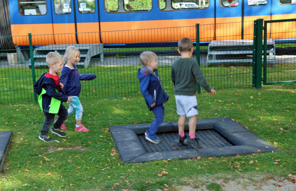 Kinder der CVJM-Kita Oberbarmen huepfen Trampolin auf einem Spielplatz