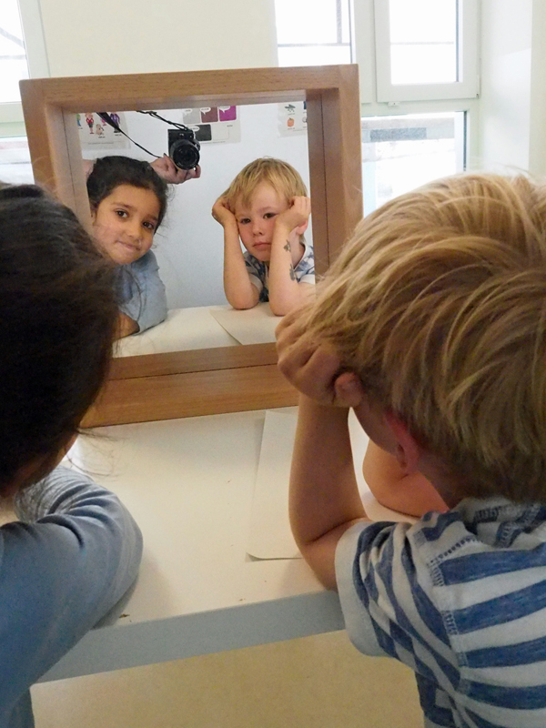 zwei-kinder-schauen-in-einen-spiegel