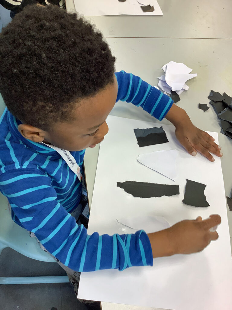 ein-kind-bastelt-mit-schwarzen-und-weissen-papierschnipseln