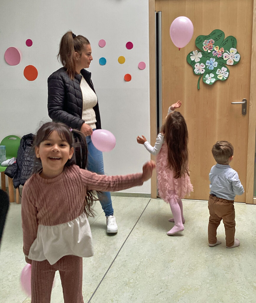 Kinder tanzen mit Luftballons