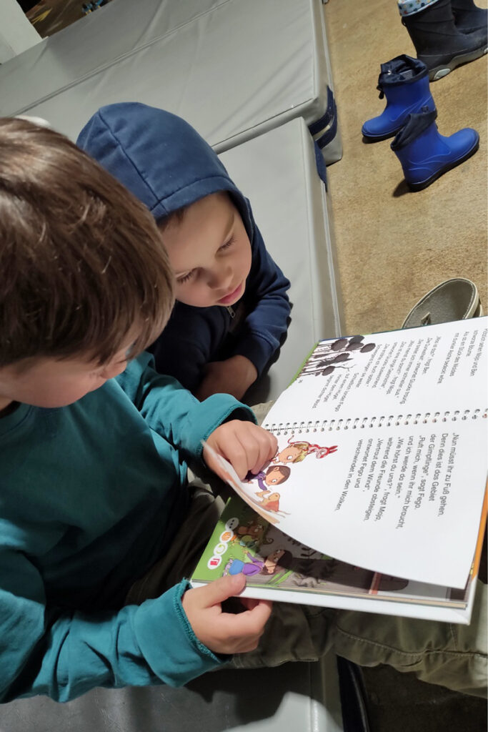 Zwei Kinder schauen sich ein Buch an