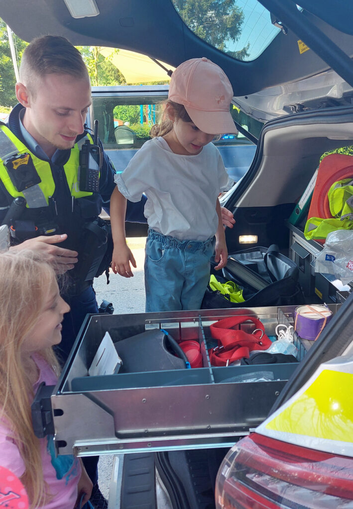 Kinder erkunden die Ausstattung eines Polizeifahrzeugs