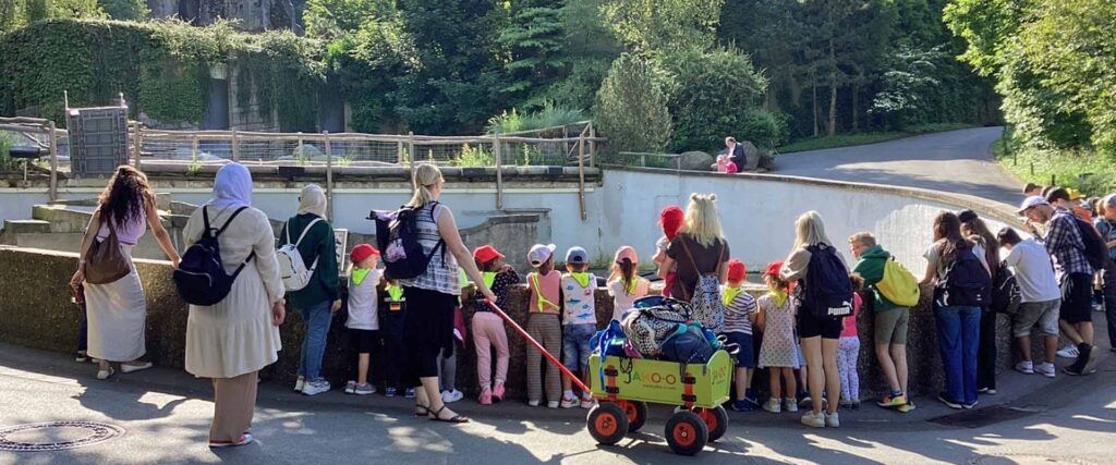 Viele Menschen stehen an der Mauer vor einem runden Tiergehege im Wuppertaler Zoo