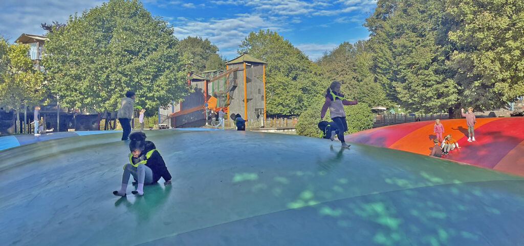 Kinder toben auf einem grossen Spielplatz herum