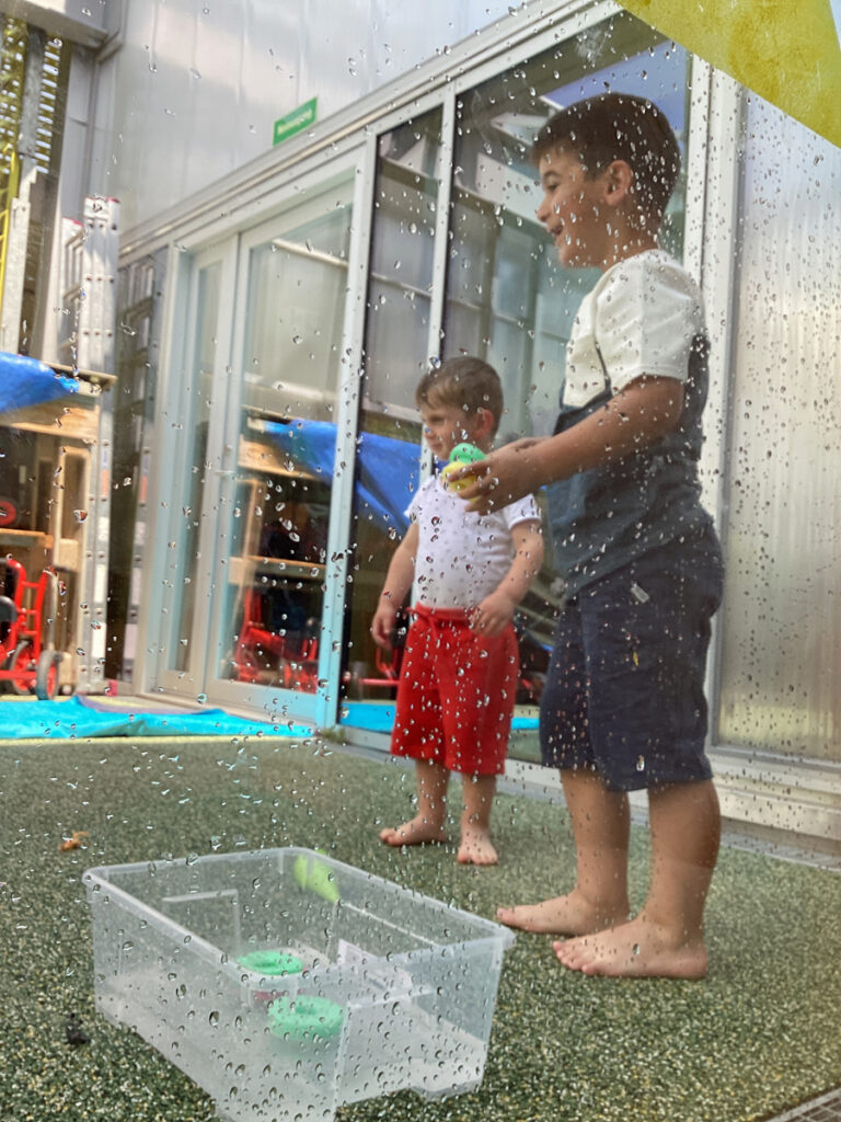 Kinder bewerfen sich auf einer Sonnenterrasse mit nassem weichem Spielzeug