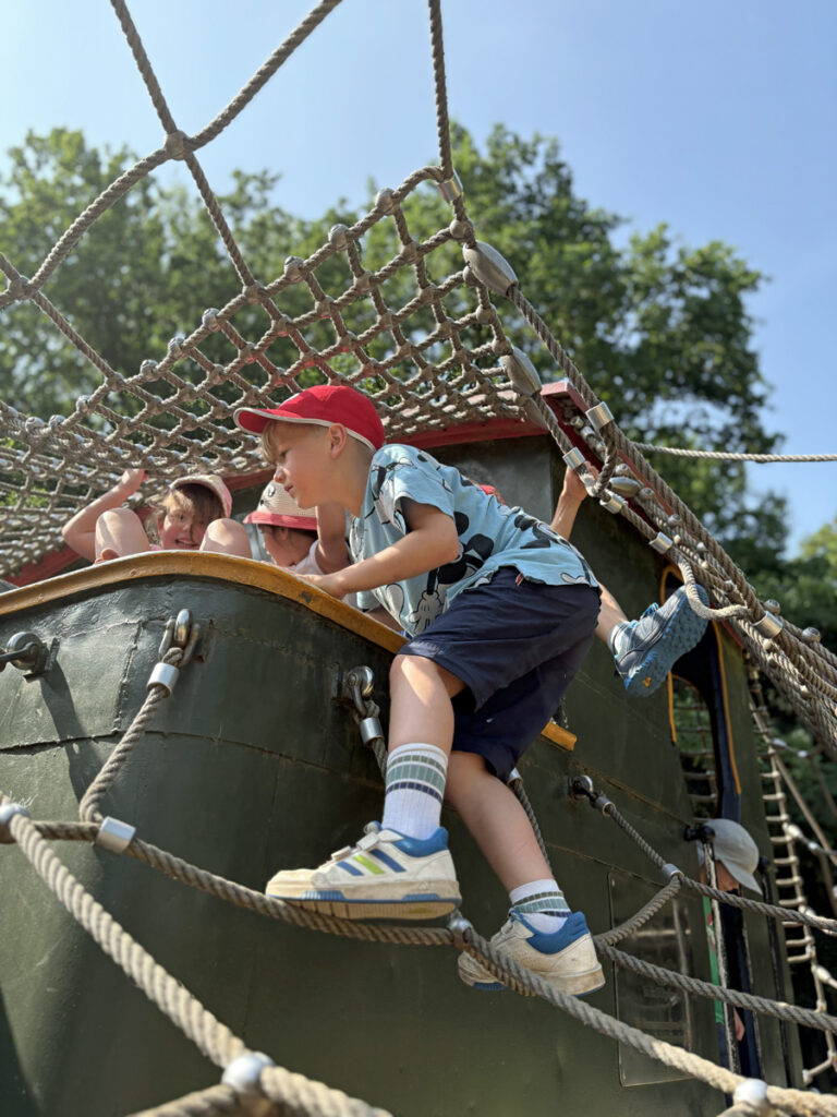 Kinder klettern auf einer Lok herum die auf einem Spielplatz steht