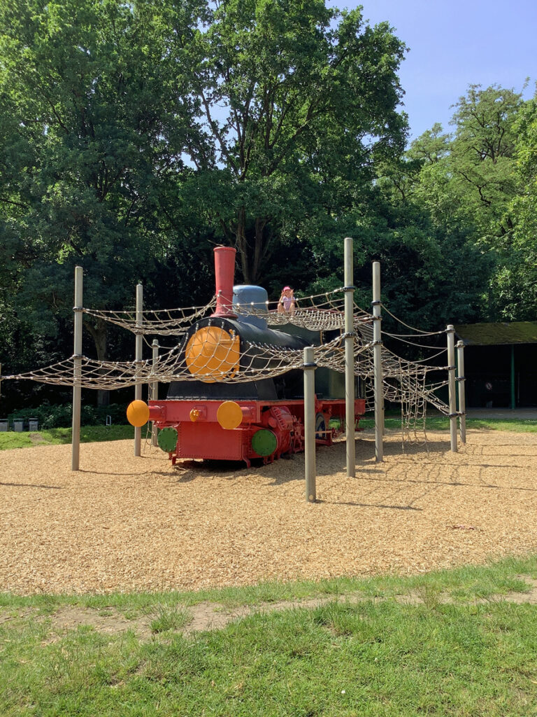 Ein Kind sitzt auf der Lokomotive auf dem Spielplatz Engelsberger Hof in Solingen