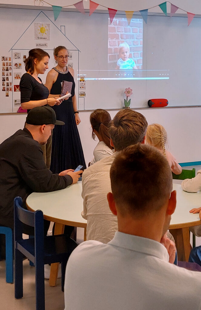 Erzieherinnen zeigen einen Film ueber ein Kind aus der Kita