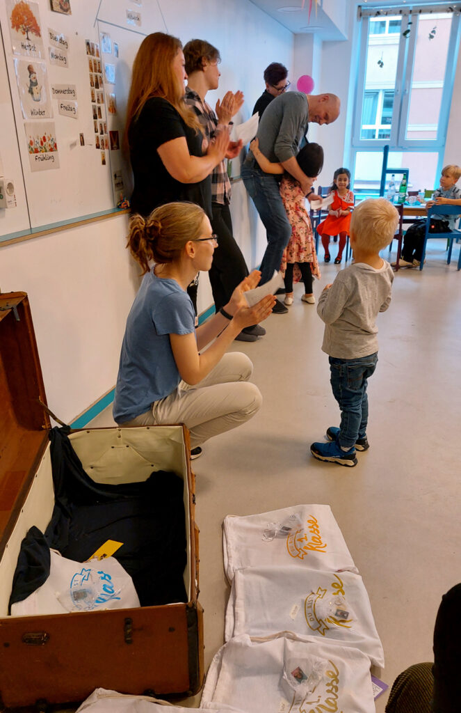 Kinder und Erwachsene feiern zusammen in der Kita ein Fest