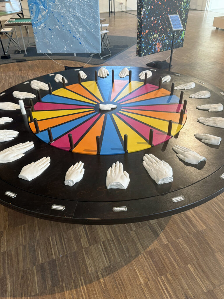 Eine Mitmachstation im Museum zeigt ein Gluecksrad mit unterschiedlich grossen Haenden aus Gips