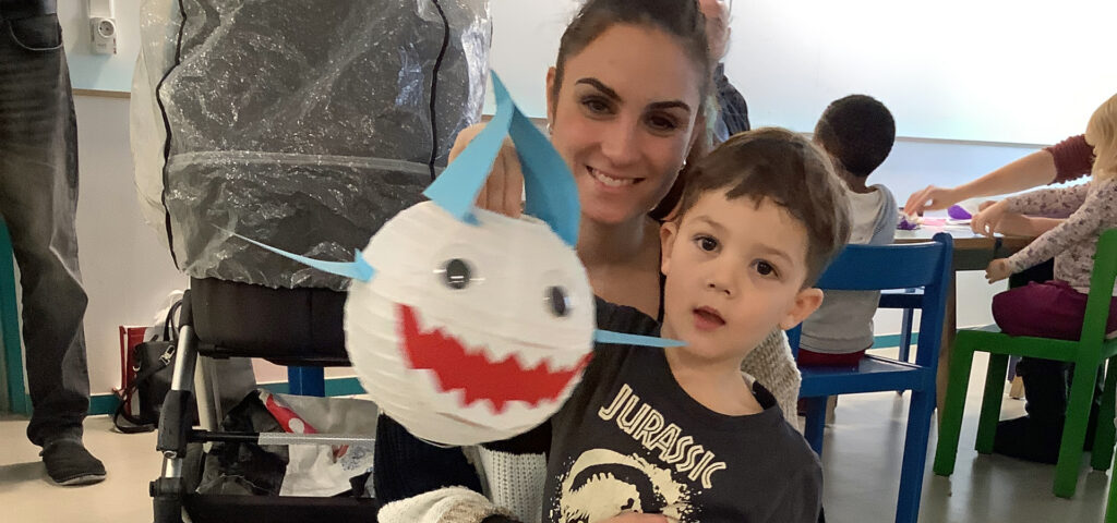 Eine Frau und ein Kind zeigen eine selbst gebastelte Hai-Laterne