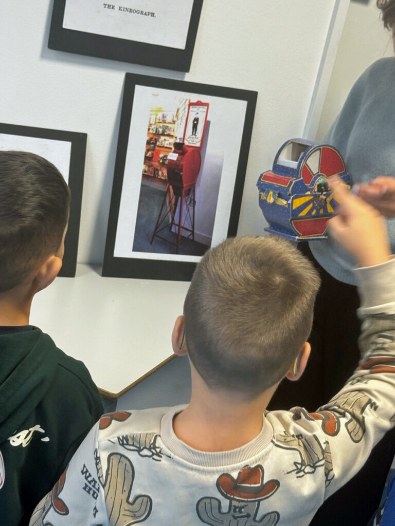 Kinder schauen Bilder und Exponate in einer Ausstellung zum Thema Kino in der Junior Uni an