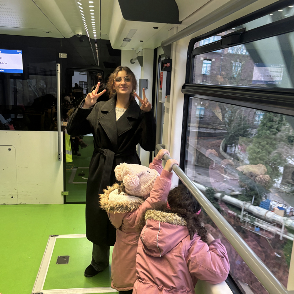 Kinder schauen aus dem Fenster einer Schwebebahn