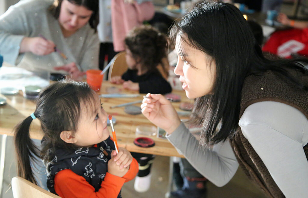 Ein Kind wird mit einem kleinen Weihnachtsmotiv geschminkt