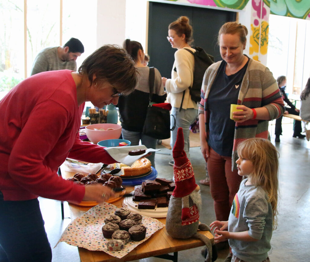 Eine Frau verteilt Kuchen an Kinder und Erwachsene