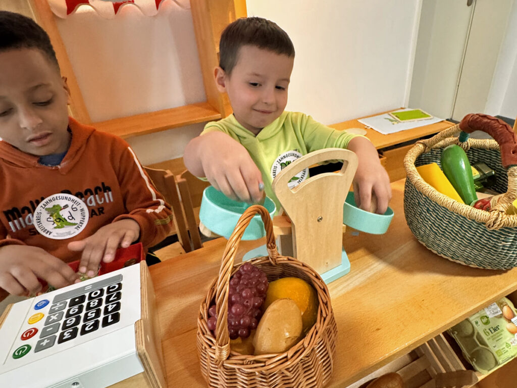 Zwei Kinder spielen mit einem Kaufladen