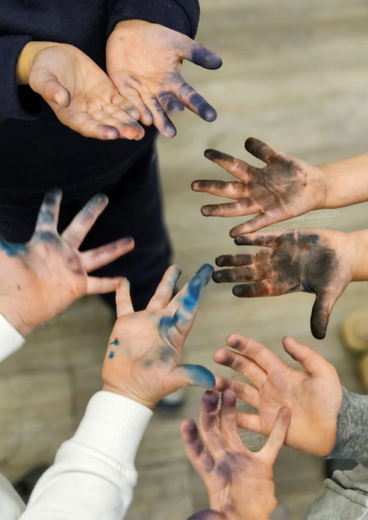 Kinder zeigen ihre bunt gefaerbten Handinnenflaechen