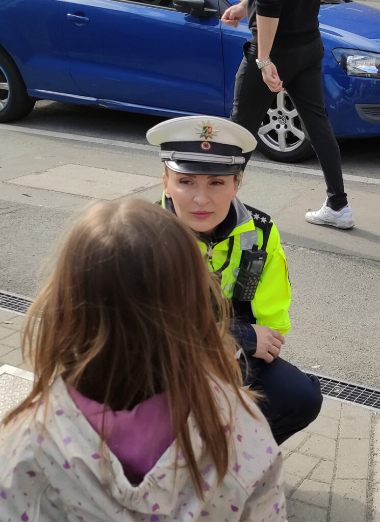 Die Polizistin spricht mit einem Kind draussen vor der Kita