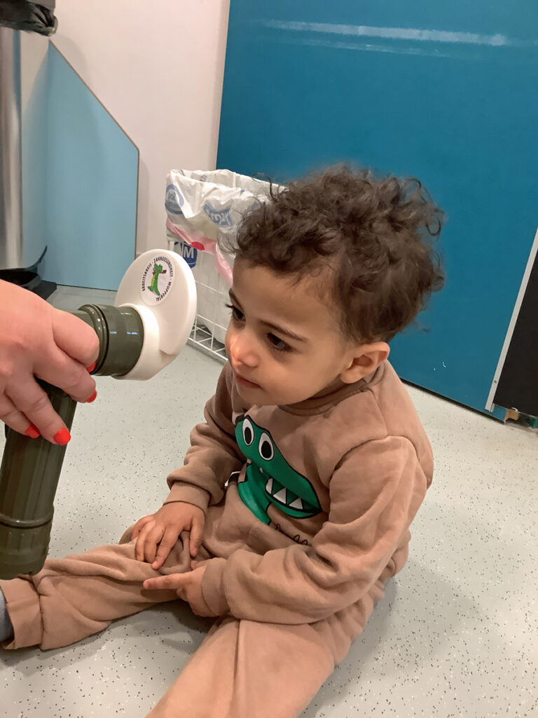 Ein kleines Kind betrachtet sein Gesicht in einem beleuchteten Spiegel