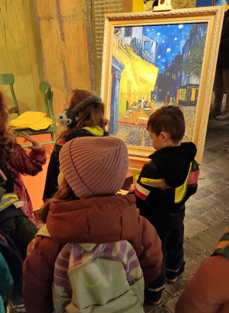 Eine Gruppe von Kindern steht in einem Ausstellungsraum vor einem Bild von Van Gogh