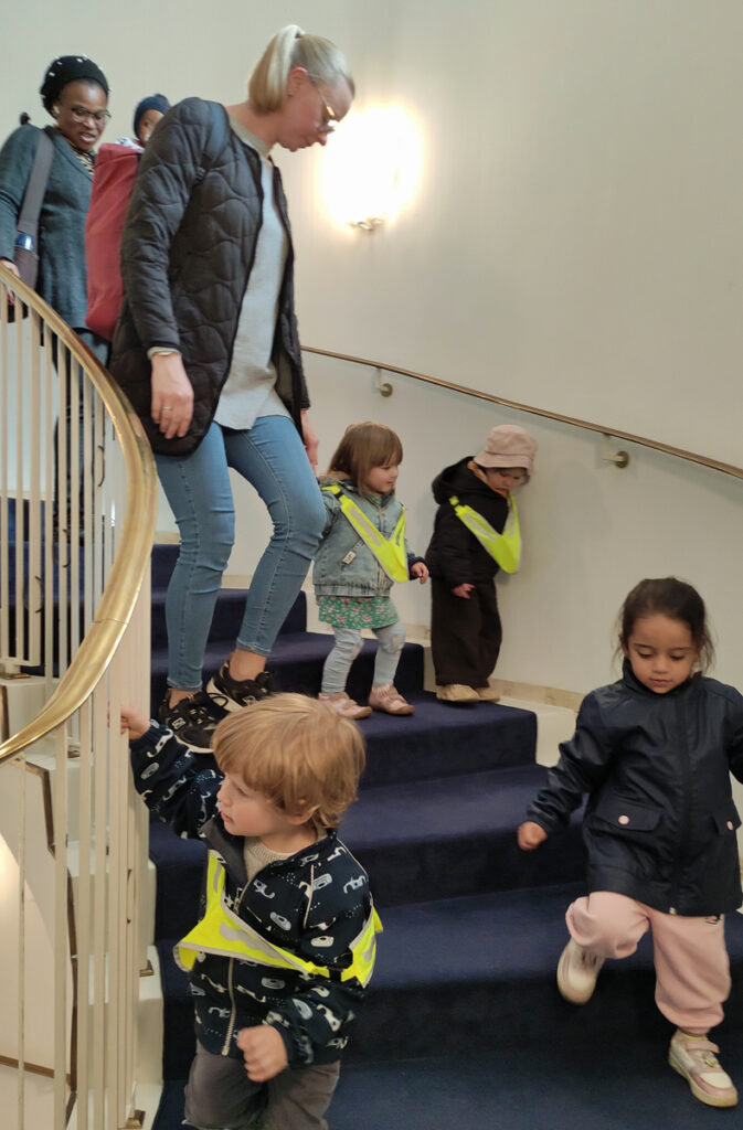 Kinder und Erwachsene gehen eine gewundene Treppe im Wuppertaler Opernhaus hinunter