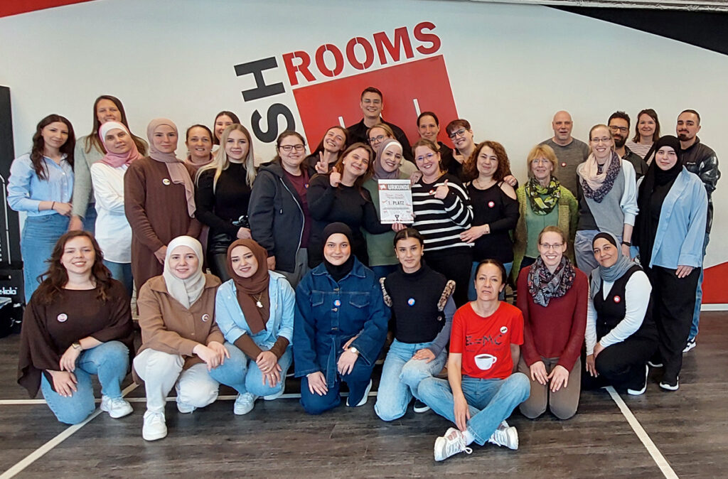 Frauen und Maenner auf einem Gruppenbild in einem grossen Raum