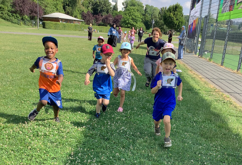 Kinder laufen um die Wette beim Sportfest der Kitas auf einer Wiese