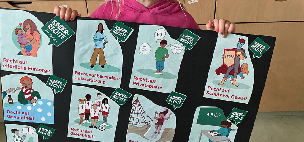 Ein Kind haelt ein Plakat auf dem Kinderrechte visualisiert sind