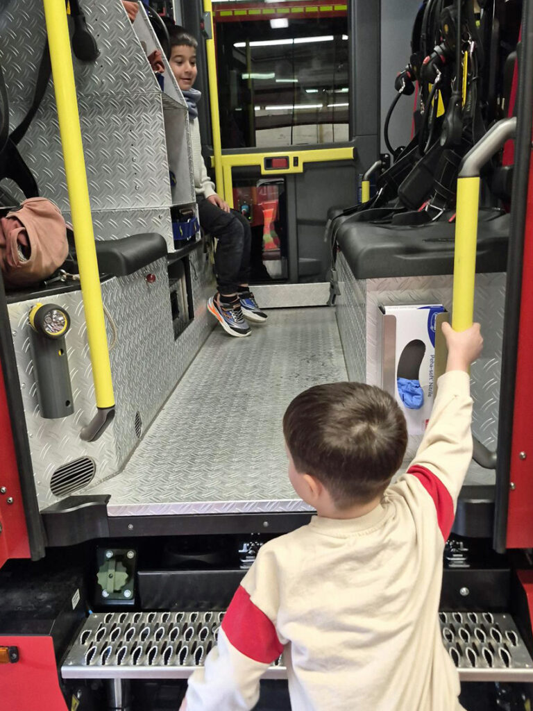 Ein Kind klettert die Stufen zum Feuerwehrauto hinauf