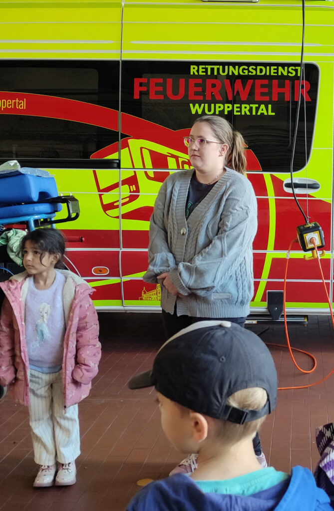 Kinder und Erwachsene stehen vor einem grossen Auto mit der Aufschrift Rettungsdienst Feuerwehr Wuppertal