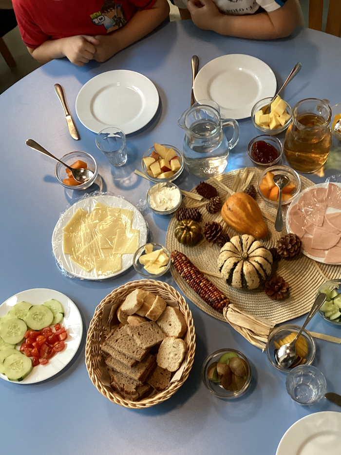 Auf dem Fruehstueckstisch stehen Brot, Kaese, Rohkost, Wurst und viele Fruechte bereit